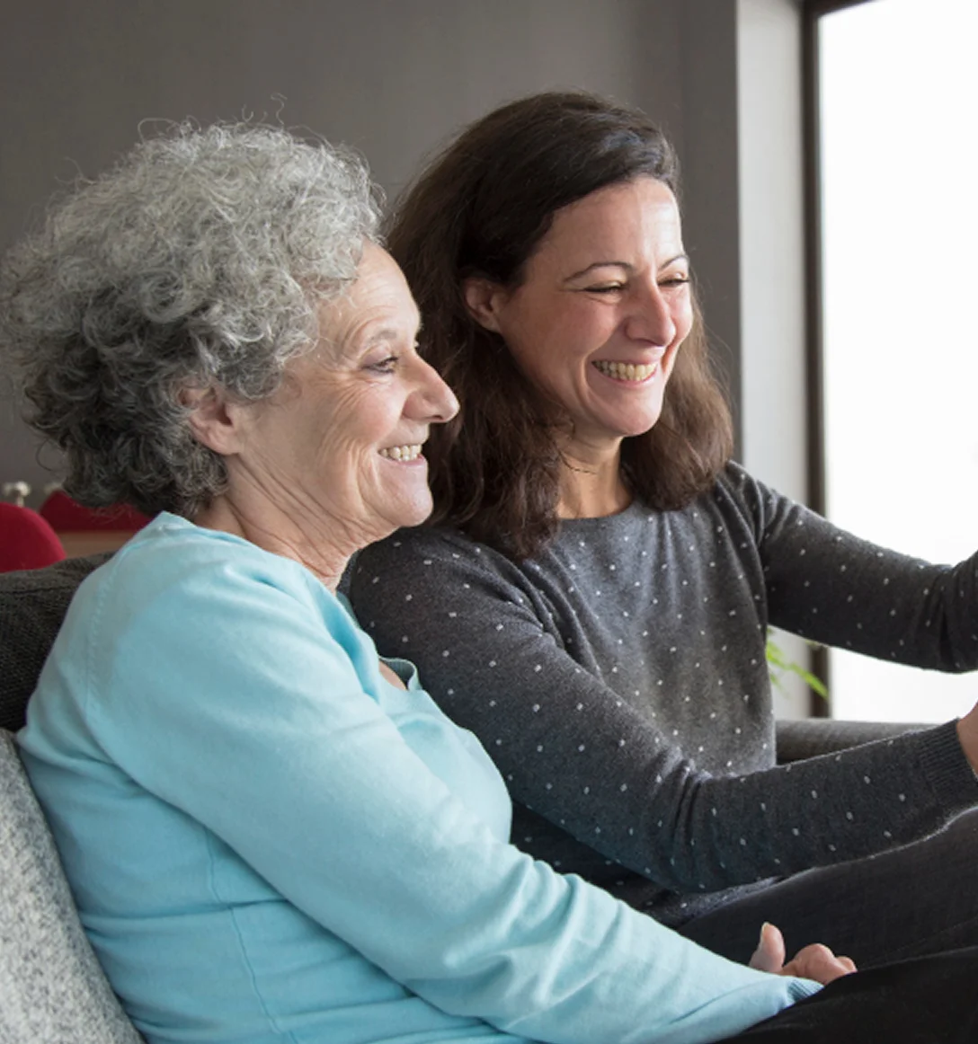 Caregiver sitting with senior woman at home